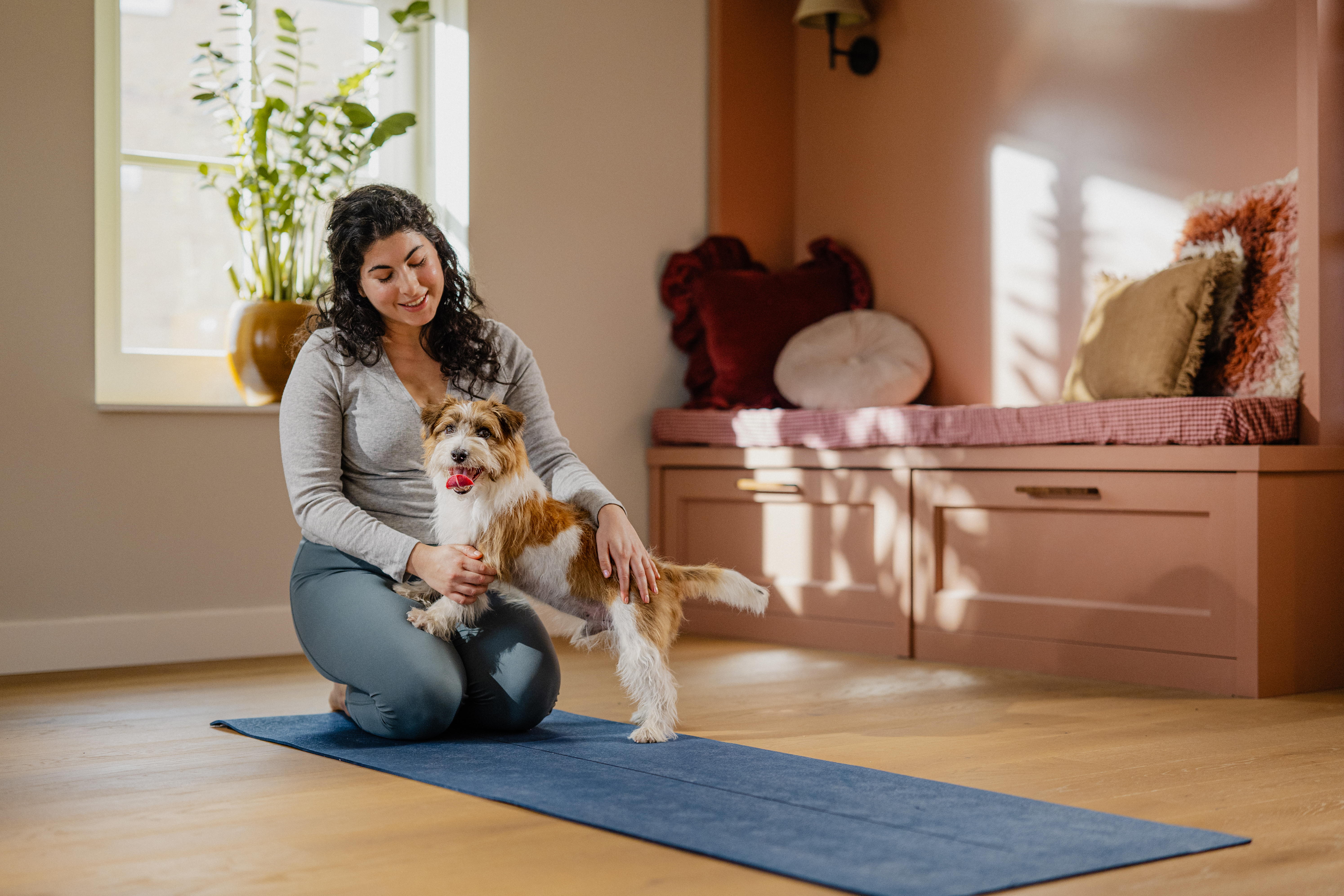 Lady stroking her dog while knelt on the floor